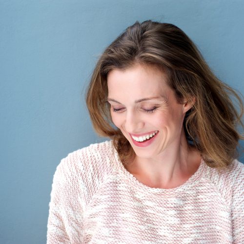 Close up portrait of a beautiful mid adult woman laughing with sweater
