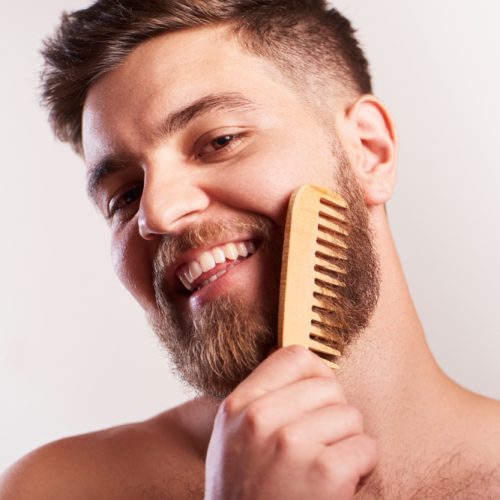 Attractive,Smiling,Bearded,Man,Holding,A,Comp,For,Beard,Standing