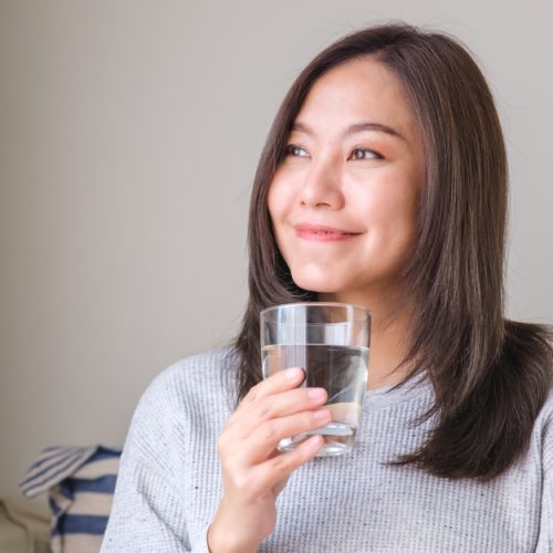 Portrait,Image,Of,A,Young,Woman,Holding,And,Drinking,Water